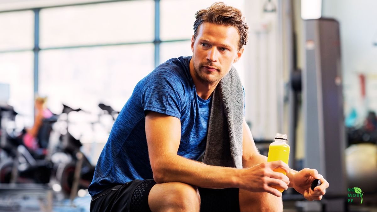 man in gym holding an energy drink